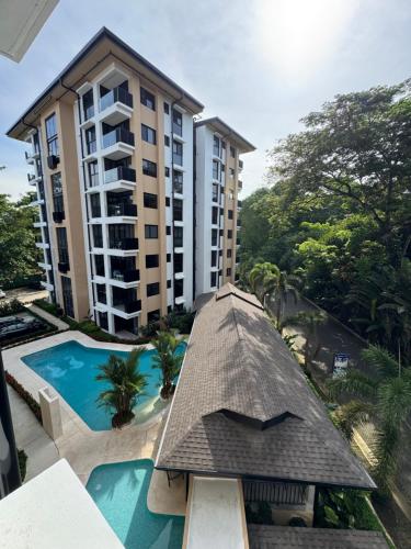 an apartment building with a swimming pool and a hotel at Vistas del Bosque Jacó in Jacó