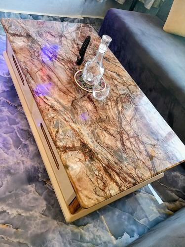 a table with a wine glass and a bottle on it at Résidence London in Laayoune