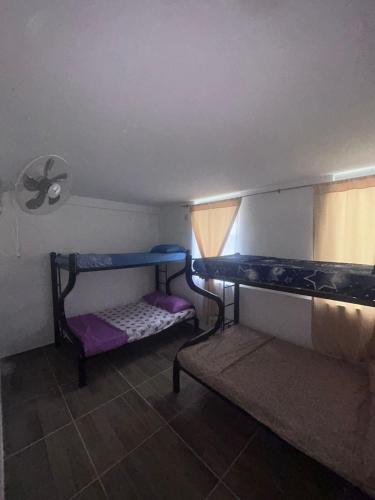 a small room with two bunk beds and a fan at Apartamento amoblado in Girardot