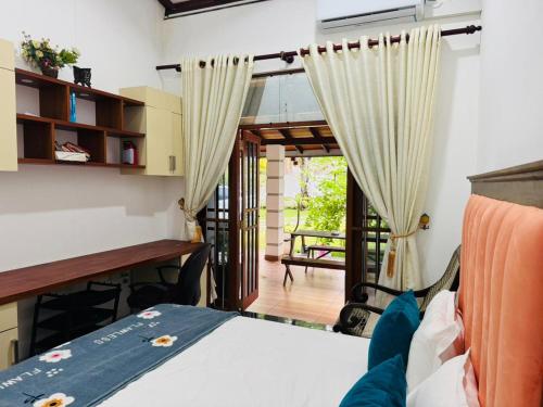 Un dormitorio con una cama, un escritorio y una mesa. en Villa Sea Breeze, en Beruwala