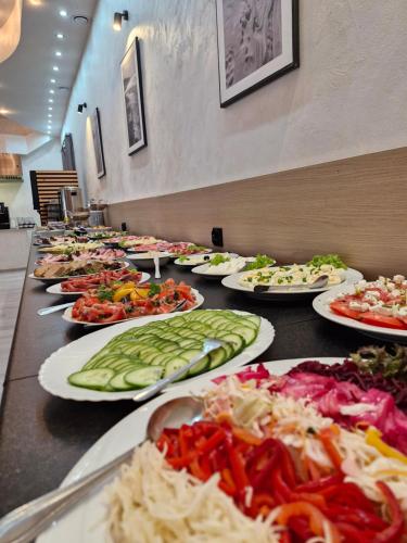 a buffet line of plates of food on a table at Posejdon in Międzyzdroje