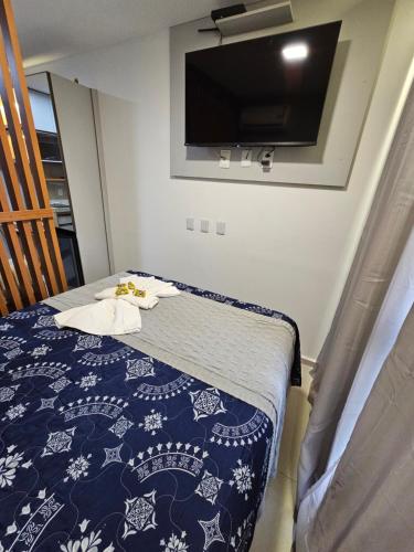a bedroom with a bed with a tv on the wall at Flat em Tamandaré, Próximo ao mar in Tamandaré
