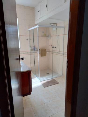 a bathroom with a shower with a glass door at Apto no centro com vista para o Cristo in Poços de Caldas