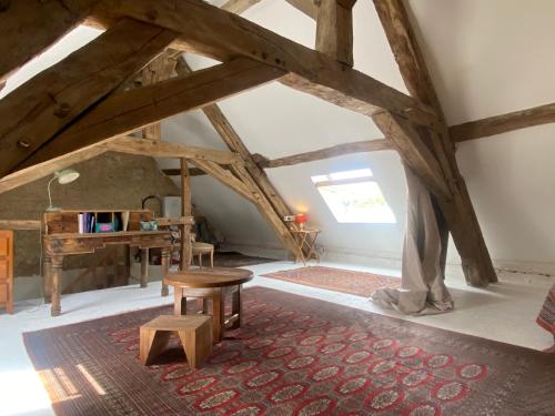 an attic room with a bench and a table in it at La maison du moulin in Lurcy-le-Bourg