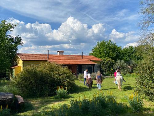 a group of people riding horses in front of a house at Casa Das Palmeiras-Pedagogic Farm in Mangualde