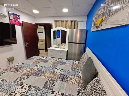 a room with a bed with a blue wall at Fully furnished bedroom c-136 in Abu Dhabi