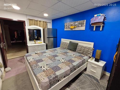 a bedroom with a bed and a blue wall at Fully furnished bedroom c-136 in Abu Dhabi