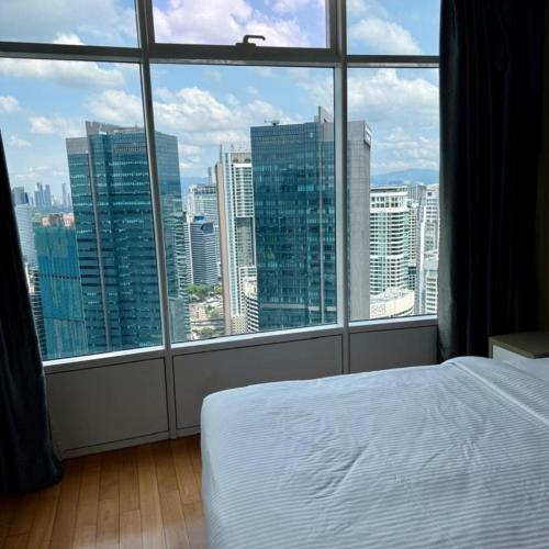 a bedroom with a view of a city from a window at Vortex luxury apartment by KL in Kuala Lumpur