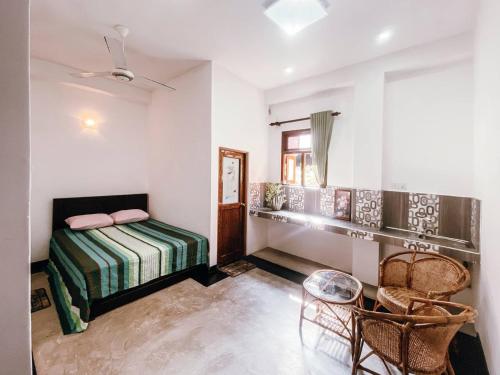 a bedroom with a bed and a table and chairs at Ceylon Heart Villa in Unawatuna
