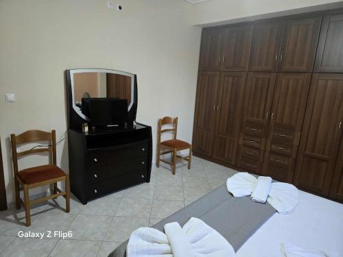 1 dormitorio con 1 cama, TV y armarios de madera en Sourlis house, en Esparta