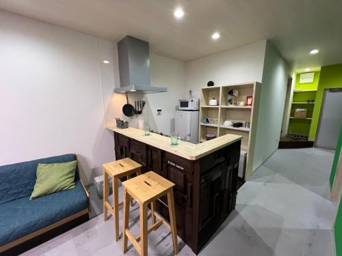 a kitchen with a couch and a counter in a room at uchimachi201 しげの里リノベーション52平方メートルJR高松駅14分ことでん片原町駅3分土足OK in Takamatsu