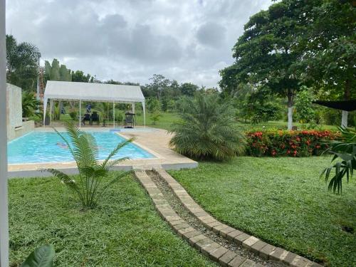 a swimming pool in a yard with a gazebo at Cómoda Finca de Descanso en Urabá in Estación El Salto