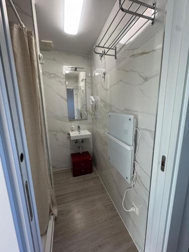 a white bathroom with a sink and a mirror at WelKom Studios in Zaventem