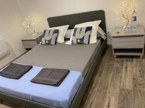 a bedroom with a large bed with blue and white pillows at Une chambre pour deux avec vue sur la piscine in Le Pizou