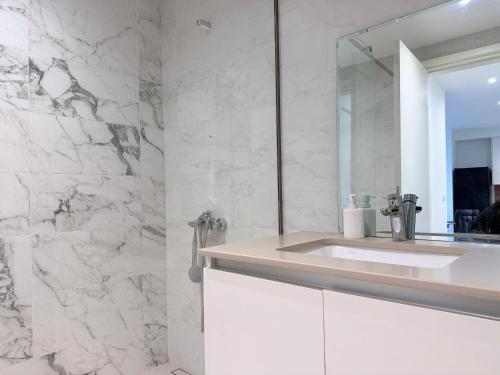 贝尔格莱德BW Arcadia RIVÉ Apartment的一间白色浴室，配有洗手池和镜子。