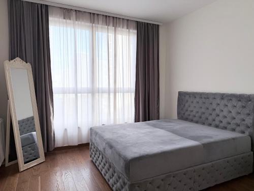 贝尔格莱德BW Arcadia RIVÉ Apartment的一间卧室，里面有一张床和一扇大窗户。