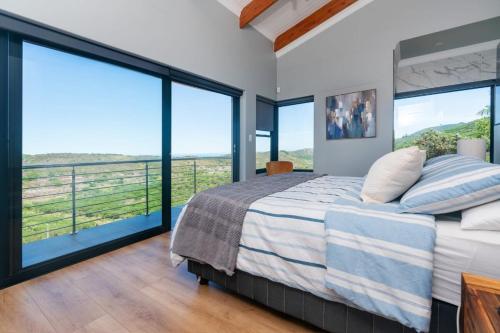 a bedroom with a large bed and large windows at FrizNite 1 in Brenton-on-Sea