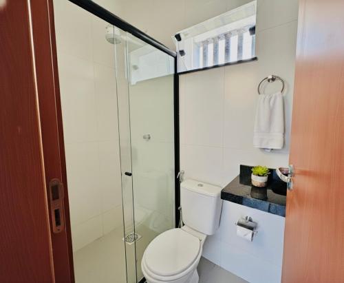 a bathroom with a toilet and a glass shower at Le Chardon Residence in Ananindeua