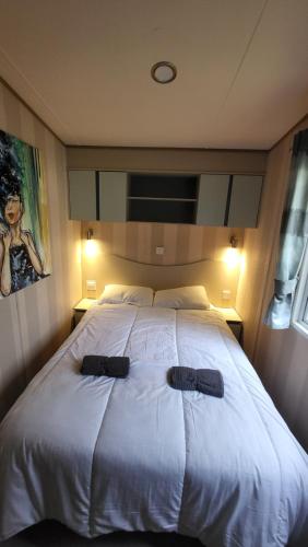 a large white bed with two black pillows on it at East Lothian Escape in Port Seton