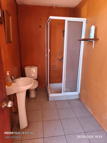 a bathroom with a shower with a toilet and a sink at Cabañas Caprumadp in Quintero