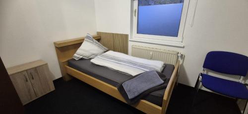 ジーゲンにあるMonteur- und Ferienwohnung Siegen Millerのベッドと窓のある小さな部屋