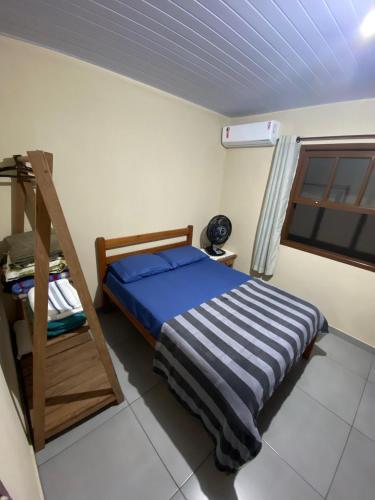 a bedroom with a bed with a ladder and a window at Casa Azul Paraty in Paraty