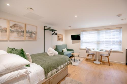 a bedroom with a bed and a table and chairs at Lindenstone Stylish & Comfortable Stays in the Heart of Maidstone in Maidstone