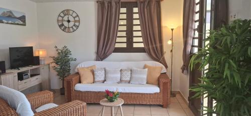 a living room with a couch and a tv at Le Voyageur in Sainte-Marie