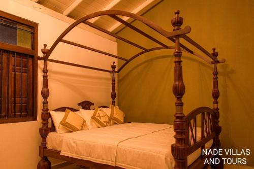 a bed with a wooden frame in a room at Nade Villas Madu River Rest in Balapitiya