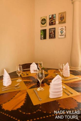 a table with wine glasses and napkins on it at Nade Villas Madu River Rest in Balapitiya
