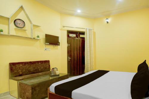 a bedroom with a bed and a couch and a clock at Hotel O Krishna Palace in Jaipur