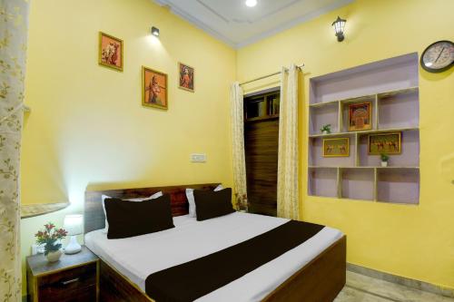 a bedroom with a bed and a clock on the wall at Hotel O Krishna Palace in Jaipur