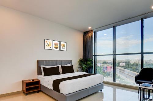 een slaapkamer met een bed en een groot raam bij Hotel O Lotus Inn in Chinchwad
