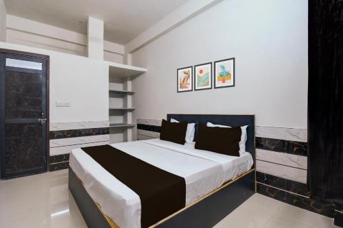 a bedroom with a large bed with black and white sheets at Hotel O Royal Palace Hotel in Sheodāspura