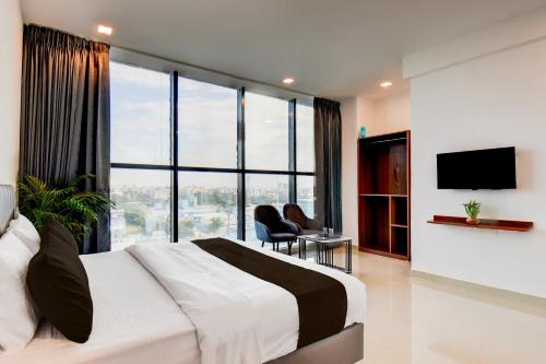 een slaapkamer met een groot bed en een groot raam bij Hotel O Lotus Inn in Chinchwad