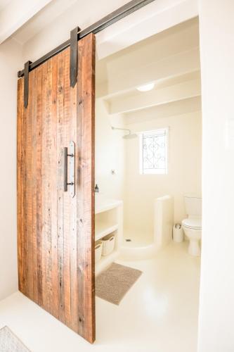a sliding barn door in a bathroom with a toilet at Klein Paradys in Kleinmond