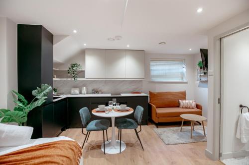 a kitchen and living room with a table and chairs at Lindenstone Stylish & Comfortable Stays in the Heart of Maidstone in Maidstone
