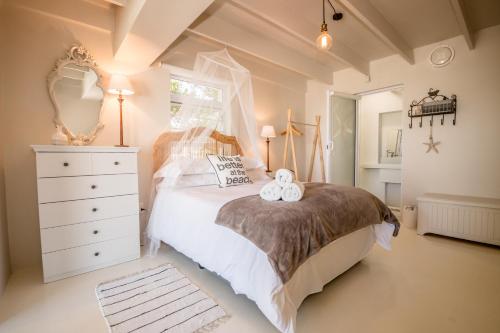 a bedroom with a bed with two towels on it at Klein Paradys in Kleinmond