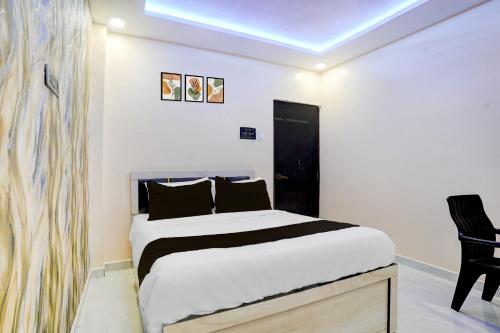 a bedroom with a bed and a black chair at HOTEL O HAVELI INN in Rāipur