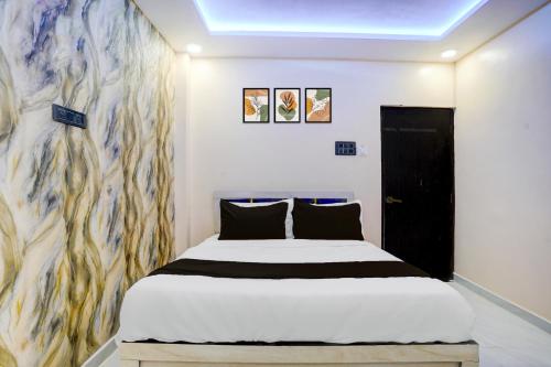 a bedroom with a bed and a painting on the wall at HOTEL O HAVELI INN in Rāipur