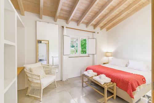 una camera da letto con un letto, una sedia e una finestra di Casa do Canal - Zambujeira do Mar a São Teotónio