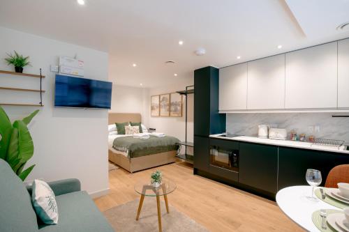 a living room with a bed and a kitchen at Lindenstone Stylish & Comfortable Stays in the Heart of Maidstone in Maidstone