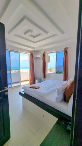 a bedroom with a large bed with a view of the ocean at SunSeaBar Beach Resort in Kendwa
