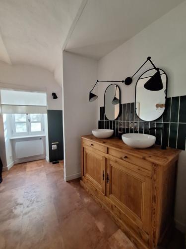 a bathroom with two sinks and two mirrors on the wall at Maison en pierre avec piscine in Ribes