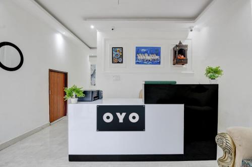 a lobby with a white counter with an omega sign on it at Hotel O Celebration in Indraprast