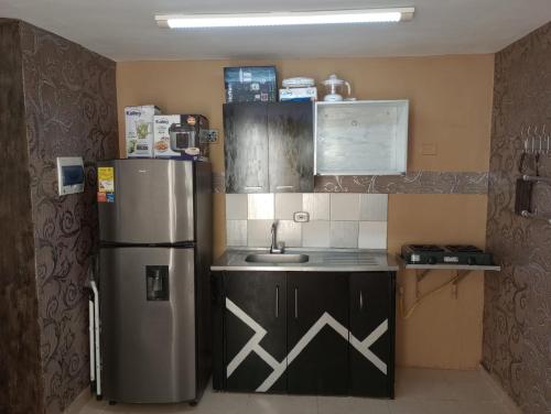 a kitchen with a refrigerator and a sink at Deluxury in Santa Marta