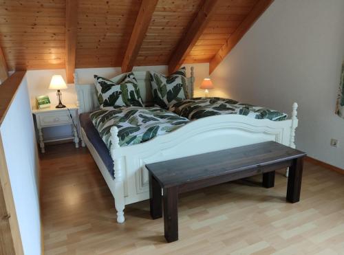 a bedroom with a white bed and a wooden ceiling at Casa Luna in Herdwangen-Schönach