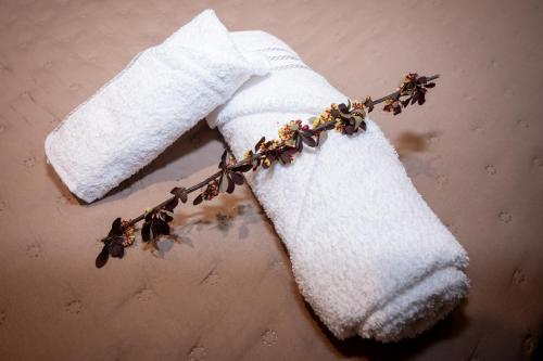 een witte handdoek met gedroogde bloemen op een stokje bij Apart Stay in El Calafate