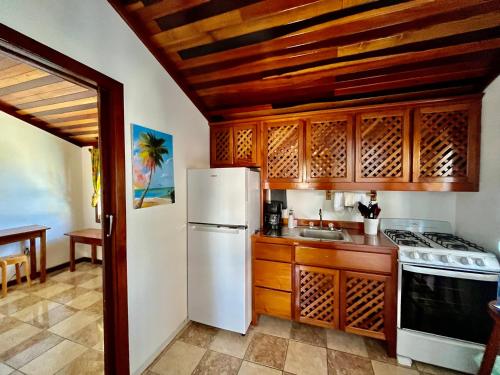 a kitchen with a white refrigerator and a sink at Colinda Cabanas in Caye Caulker