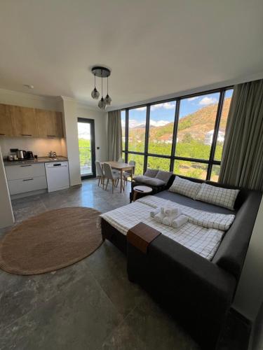 a living room with a black couch and a table at Mirşah Suit in Bezkesen